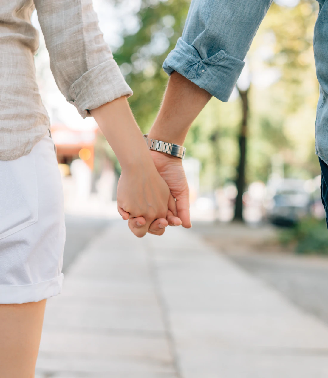 A couple walking together hand in hand down a path